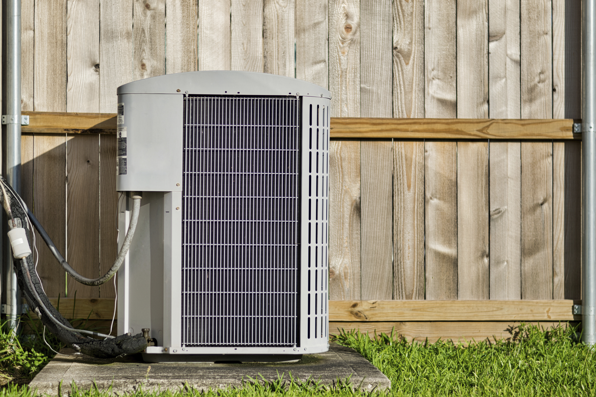 outdoor AC unit next to wood fence outside Ohio home