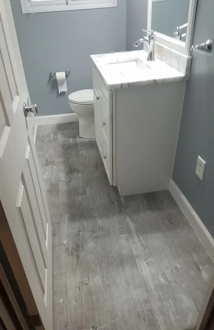 A newly renovated bathroom with a vanity sink and new toilet