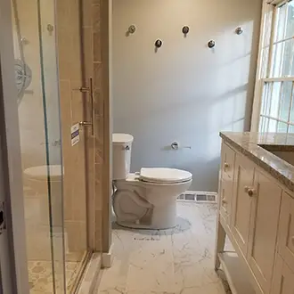 A newly renovated bathroom with a vanity sink and new toilet