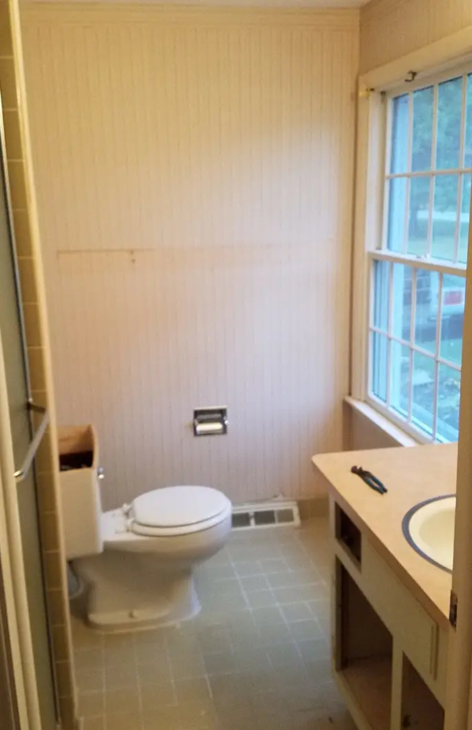 A bathroom with a white, newly installed toilet and a visible sink basin