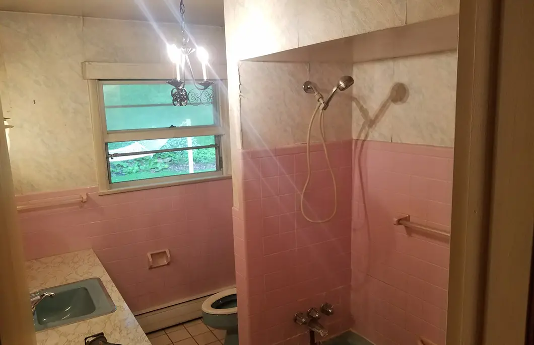 A pink and white bathroom with a teal toilet and sink basin