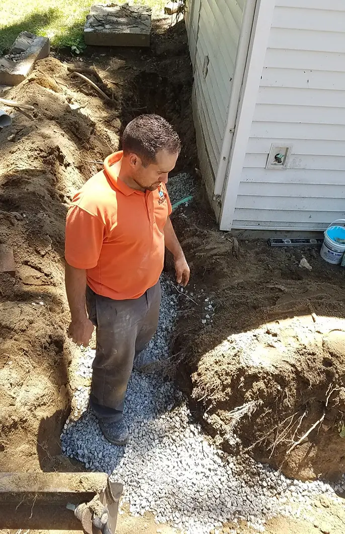 A Kobella technician digging outside a customer's home for a piping project