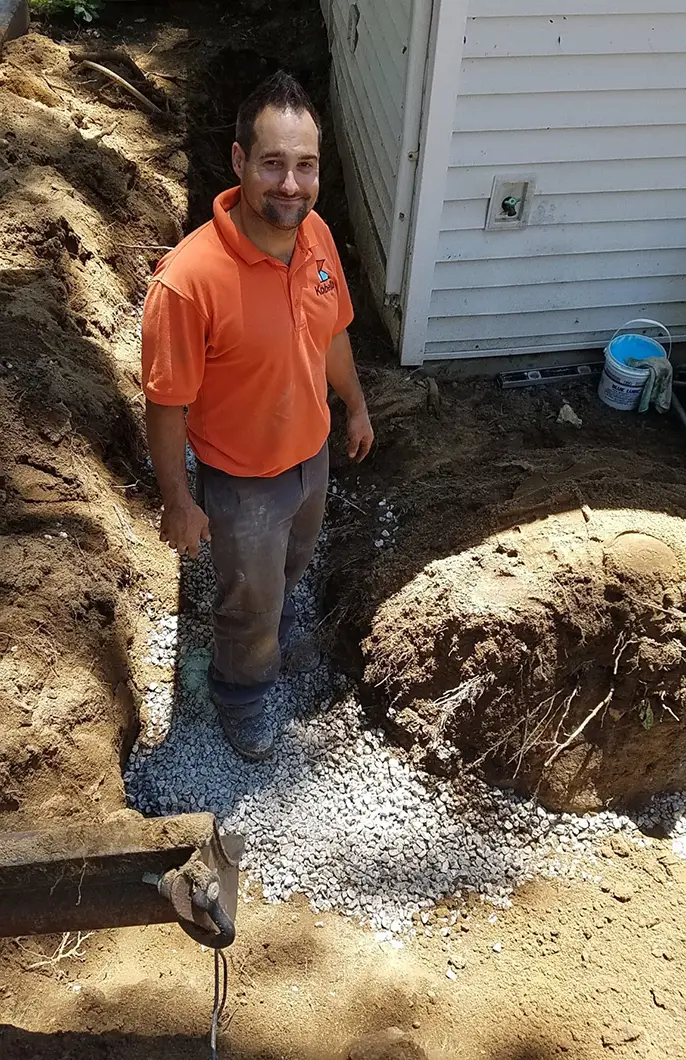 A Kobella technician in his uniform working in a customer's yard