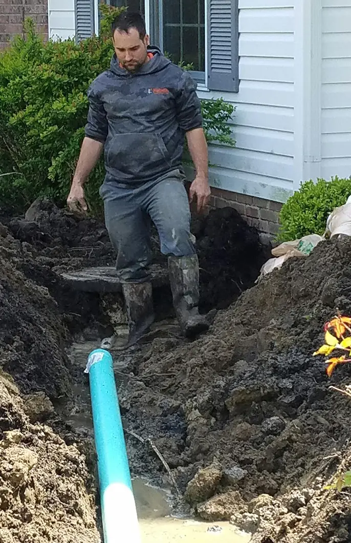 A Kobella technician digging outside a customer's home for a piping project