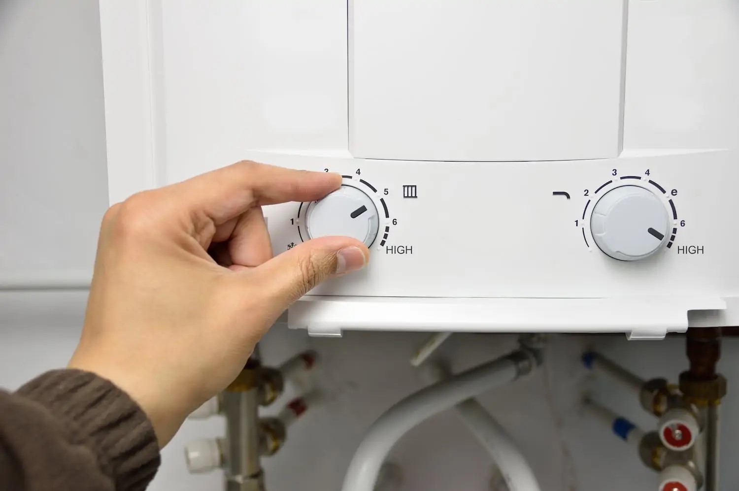 Homeowner adjusting temperature settings on water heater