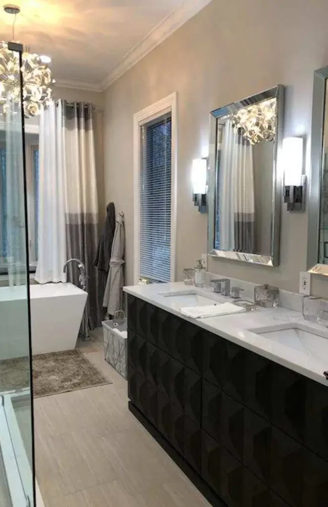 A newly renovated bathroom with a vanity sink, new bathtub, and several light fixtures