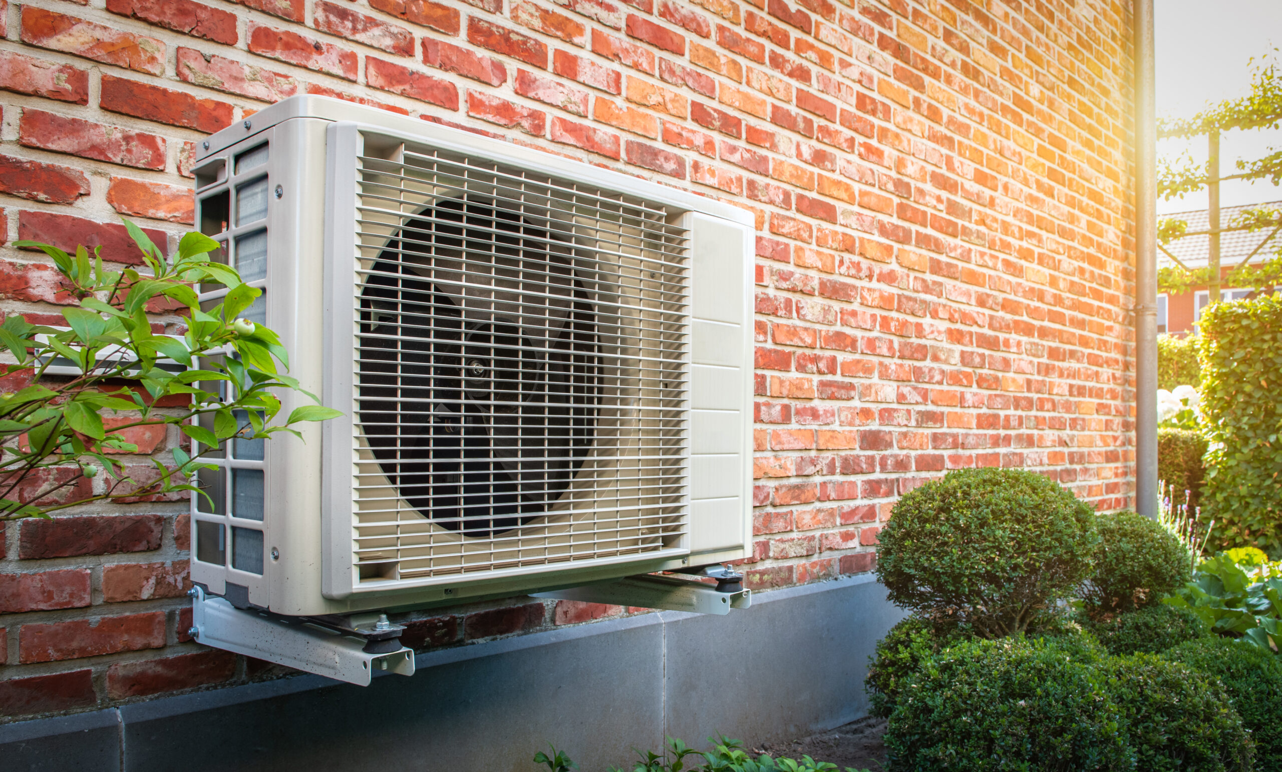 Mounted heat pump unit outside brick house