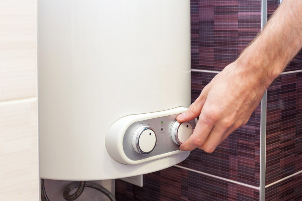 Homeowner adjusting temperature on tankless water heater unit